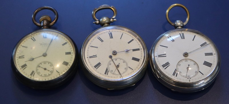 Two silver pocket watches and one other pocket watch.